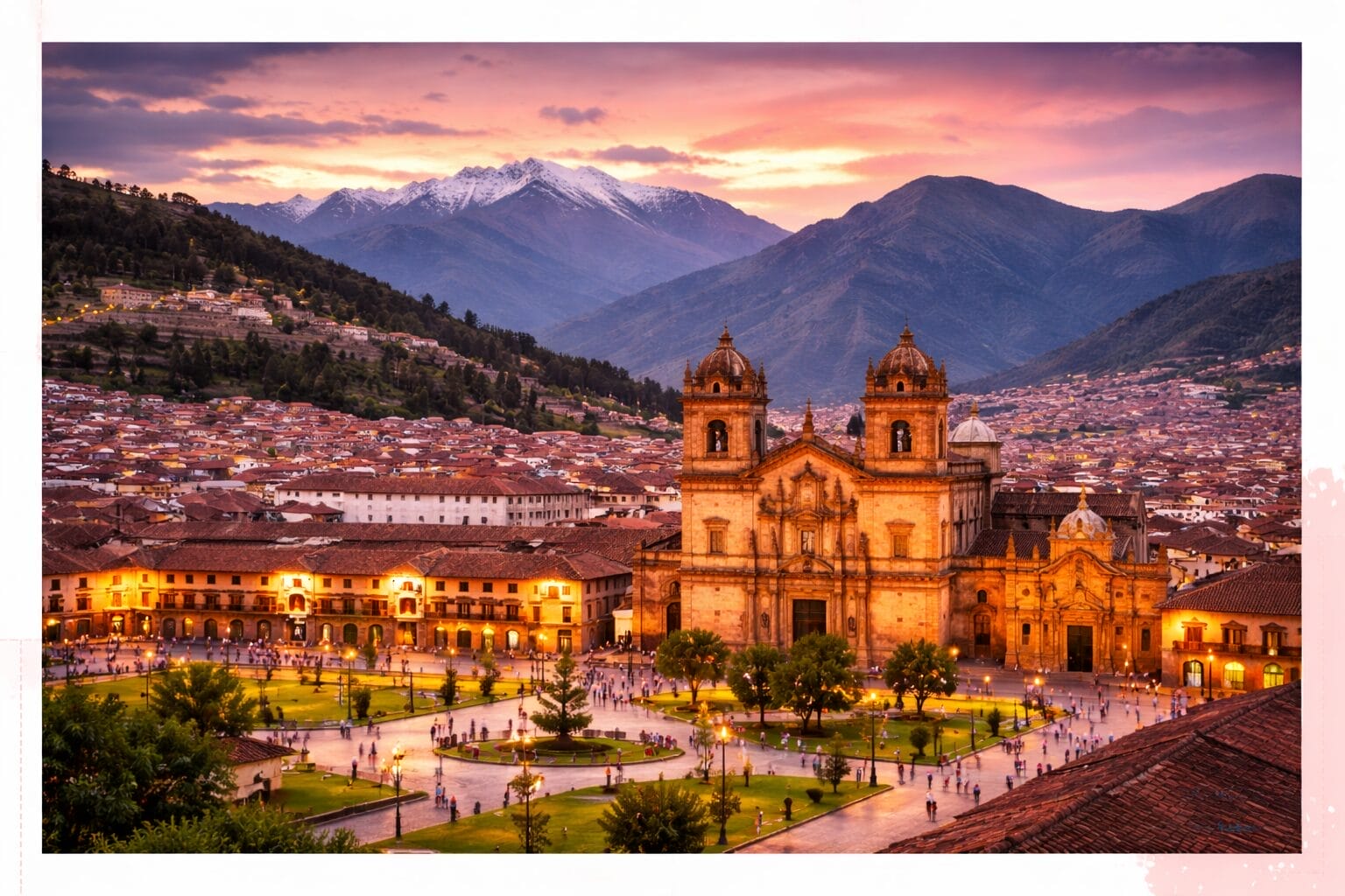 Aerial view of Cusco’s Plaza de Armas at sunset with the Cathedral of Cusco, city buildings, and snow-capped mountains in the background.